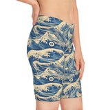Side shot of the Great Wave shorts worn by a female model, showing dynamic art and body-hugging silhouette.
